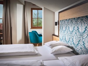 Zimmeransicht des Hotel Prinz-Luitpold-Bads in Bad Hindelang mit Blick auf ein gemütliches Doppelbett