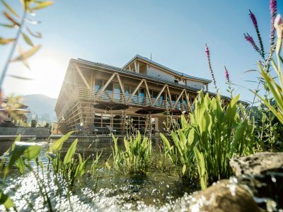 Die Außenansicht des HUBERTUS Mountain Refugios Allgäu in Balderschwang mit Außenpool und Bergpanorama