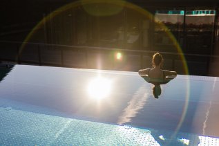 Eine Frau schwimmt am Rande des neuen Infinity Pools im Hotel Franks in Oberstdorf