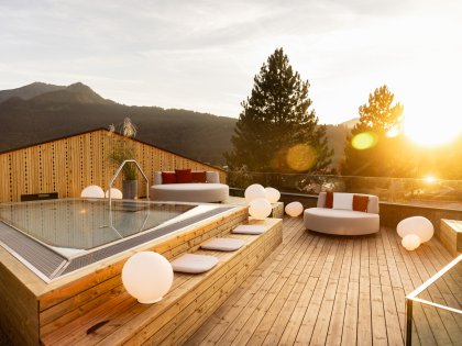 Außenansicht vom Wellnessbereich im Hotel Franks in Oberstdorf mit Blick auf den Whirlpool und Sitzgelegenheiten