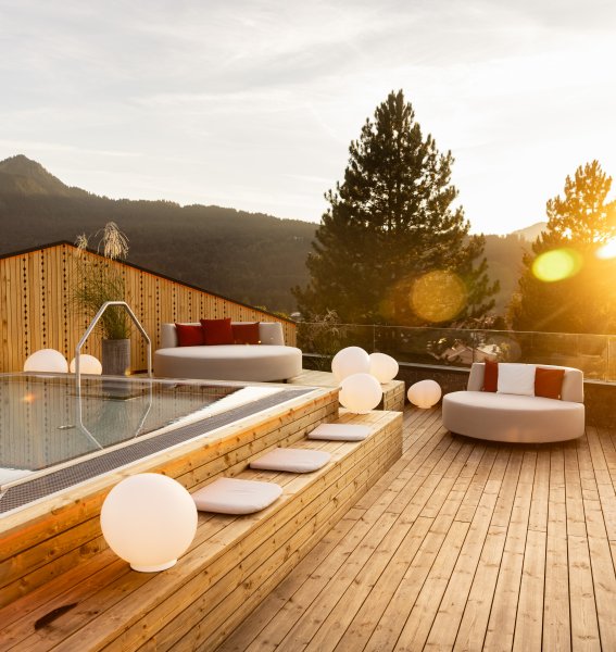 Außenansicht vom Wellnessbereich im Hotel Franks in Oberstdorf mit Blick auf den Whirlpool und Sitzgelegenheiten