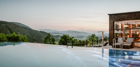 Bild mit Blick über den Infintiypool und im Hintergrund die Bergkette bei Oberstaufen