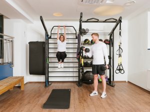 Zwei Gäste trainieren im gut ausgestatteten Fitnessraum im Mondi Resort in Oberstaufen