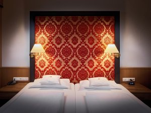 Blick auf ein gemütliches Doppelbett in einem der Zimmer im Hotel Prinz-Luitpold-Bads in Bad Hindelang