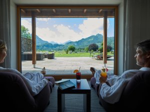 Zwei Gäste im SCHÜLE'S Gesundheitsresort & SPA in Oberstdorf liegen auf gemütlichen Ruheliegen im Wellnessbereich und entspanne