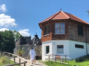 Ein Gast läuft im Außenbereich des Biohotel Eggensberger in Füssen / Hopfen am See Richtung Hotel