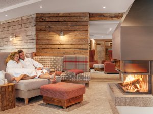 Ein Paar entspannt im gemütlichen Kaminzimmer im Hotel Oberstdorf