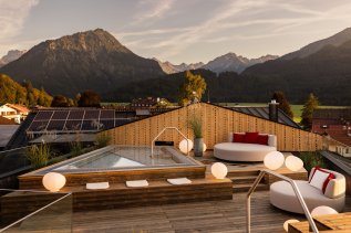 Außenansicht vom Wellnessbereich im Hotel Franks in Oberstdorf mit Blick auf den Whirlpool und Sitzgelegenheiten