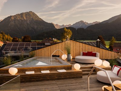 Außenansicht vom Wellnessbereich im Hotel Franks in Oberstdorf mit Blick auf den Whirlpool und Sitzgelegenheiten