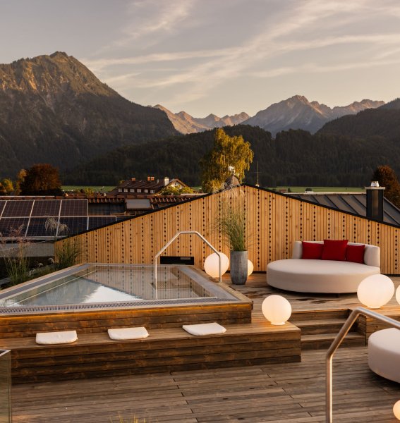 Außenansicht vom Wellnessbereich im Hotel Franks in Oberstdorf mit Blick auf den Whirlpool und Sitzgelegenheiten
