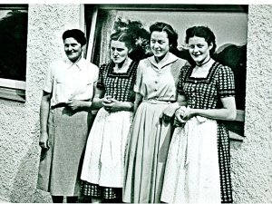 Ansicht von vier Frauen vor einer Wand des Hotel Kühberg in Oberstdorf. Das Foto ist eine ältere Aufnahme in schwarz-weiß.