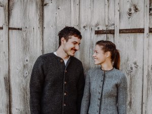 Ansicht einer Frau und eines Mannes, die vor einer Hütte stehen und sich gegenseitig anschauen.