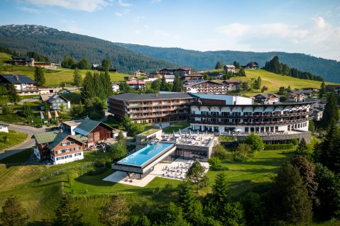 Es ist das Travel Charme Ifen Hotel im Kleinwalsertal von außen im Sommer zu sehen.