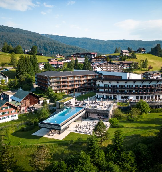 Es ist das Travel Charme Ifen Hotel im Kleinwalsertal von außen im Sommer zu sehen.