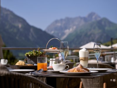 Es ist ein Tisch mit Frühstück darauf zu sehen auf der Terrasse des Travel Charme Ifen Hotel im Kleinwalsertal