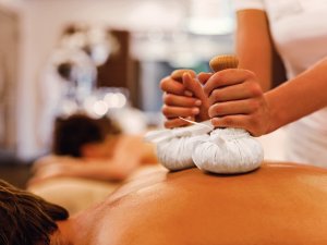 Auf dem Bild genießt ein Gast des Travel Charme Ifen Hotel im Kleinwalsertal eine Stempelmassage.