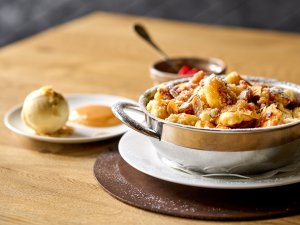 Es ist ein schön angerichteter Silberteller mit Kaiserschmarn im  Travel Charme Ifen Hotel im Kleinwalsertal zu sehen