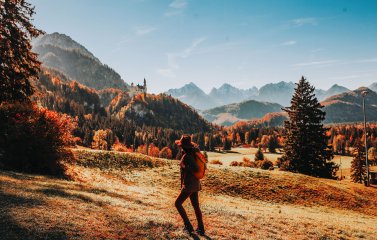 Es ist eine Person zu sehen, die eine Wanderung im Herbst unternimmt.