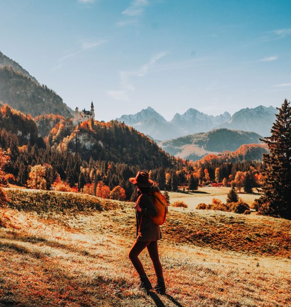 Es ist eine Person zu sehen, die eine Wanderung im Herbst unternimmt.