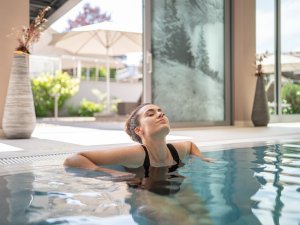 Es ist eine Frau zu sehen, die gerade im Pool des Hotels Exquisit in Oberstdorf relaxt.