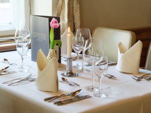 Es ist ein schön gedeckter Tisch zum Abendessen im Hotel Mohren in Oberstdorf zu sehen.