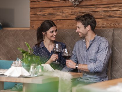 Es ist ein Paar zu sehen, welches ein Abendessen im Berwanger Hof in Obermaiselstein genießt.