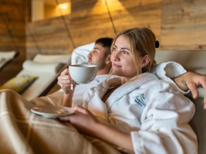 Ein Paar liegt auf einer der gemütlichen Liegen im Wellnessbereich des Biohotel Eggensberger in Füssen / Hopfen am See