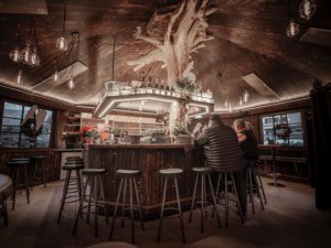Urige Bar im Hotel Restaurant Adler in Oberstaufen mit viel Holz und dem Bartresen mitten im Raum