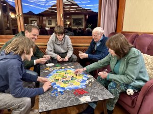 Eine Familie sitzt im Hotel Prinz-Luitpold-Bad in Bad Hindelang beisammen und spielt ein Spiel