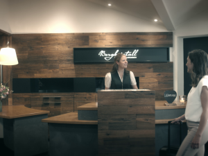 Zwei Gäste werden an der Rezeption im Bergkristall - Mein Resort im Allgäu in Oberstaufen von einer Mitarbeiterin empfangen