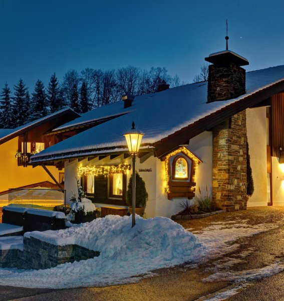 Außenansicht vom DIANA Naturpark Hotel in Oberstaufen im Winter mit schöner Beleuchtung am Abend