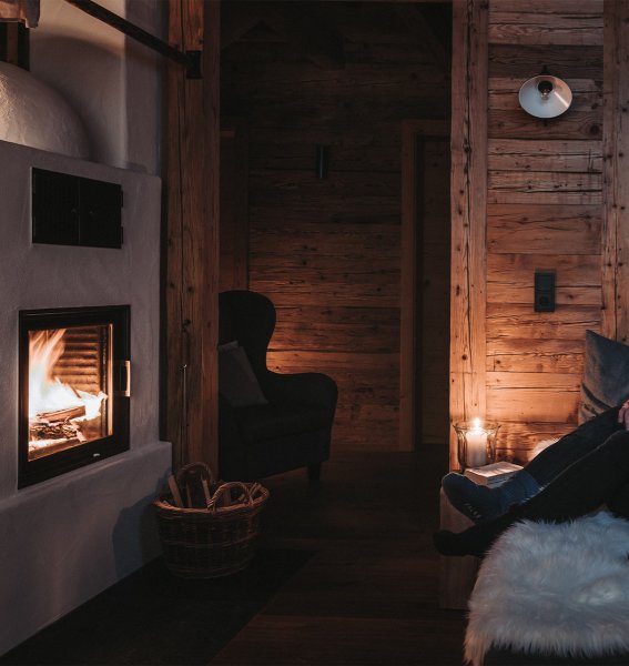 Ein Paar im Alpzitt Chalet im Dorf in Burgberg vor gemütlichem Kaminfeuer