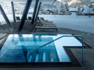 Ausblick auf einen Außenpoolzugang im Ifen Hotel Kleinwalsertal außerdem mit Blick auf die verschneite Landschaft