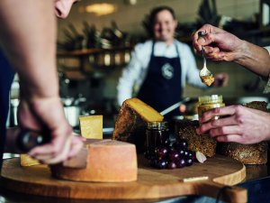 Käse wird aufgeschnitten und ist dekorativ platziert im Ifen Hotel Kleinwalsertal