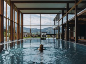 Eine Frauu schwimmt im Innenpool im Rosenalp Gesundheitsresort & Spa in Oberstaufen