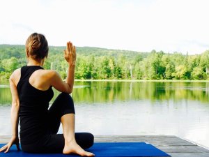 Ein Gast im Hotel Bannwaldsee in Halblech beim Yoga an einem Steg