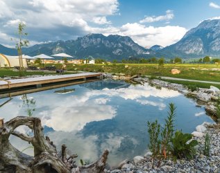 Einblick in den Garten mit Naturteich im Hotel Das Rübezahl in Schwangau im Sommer