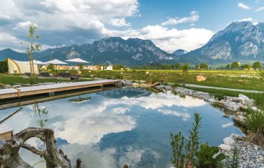 Einblick in den Garten mit Naturteich im Hotel Das Rübezahl in Schwangau im Sommer