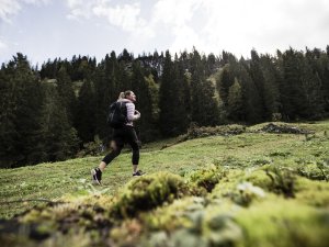 Eine Person bei einer Wanderung in den Bergen in der direkten Umgebung des Hotels HUBERTUS Mountain Refugio Allgäu in Balderschwang
