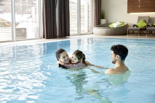 Eine Familie schwimmt im Pool im Panoramahotel Oberjoch.