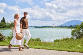 Ein Paar spaziert am Forggensee in der Nähe des Hotels Sommer in Füssen.
