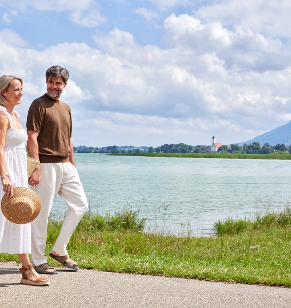 Ein Paar spaziert am Forggensee in der Nähe des Hotels Sommer in Füssen.