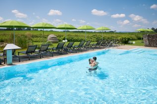 Blick auf den Außenpool bei strahlendem Sonnenschein im Das Weitblick Allgäu in Marktoberdorf.