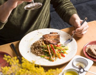 Ein Gast genießt das Abendessen und den Wein im Bio Hotel Oswalda Hus.