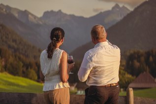 Gäste genießen ein Glas Wein auf der Terrasse des Hotels Kühberg in Oberstdorf.