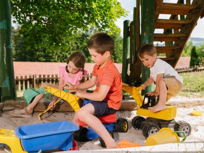 Die kleinen Gäste des Hotels Mondi Resort in Oberstaufen speilen im Sandkasten auf dem Spielplatz.