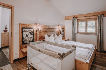 Einblick in ein Zimmer mit Babybett in der Alpe Dornach in Oberstdorf.