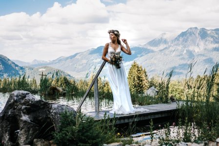 Eine Braut bei einem Fotoshooting in Mitten der Berge an der Alpe Dornach in Oberstdorf.