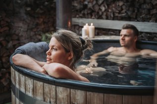 Ein Paar im Pool in den Alpzitt Chalets im Dorf in Burgberg.