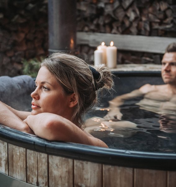 Ein Paar im Pool in den Alpzitt Chalets im Dorf in Burgberg.